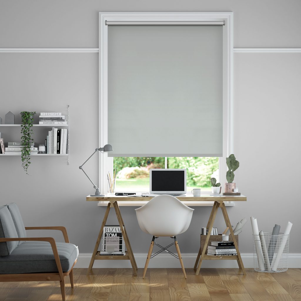 A room containing a desk at a window with a blind pulled down