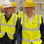 Four people wearing hard hats and high vis jackets viewing Energy House 2.0 under construction