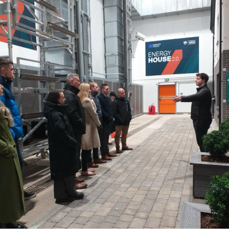 Inside Chamber one at Energy House 2.0 nine people receiving a tour from a member of the team