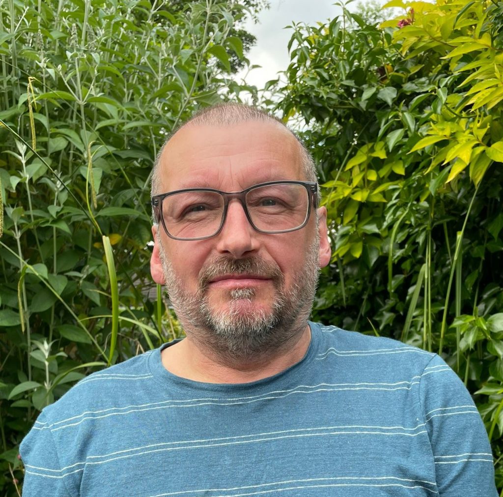 Image of Joe Flanagan, Energy House Labs Project Manager, surrounded by greenery