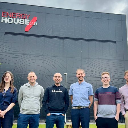 Seven employees from Nusku standing outside Energy House 2.0 at the University of Salford.